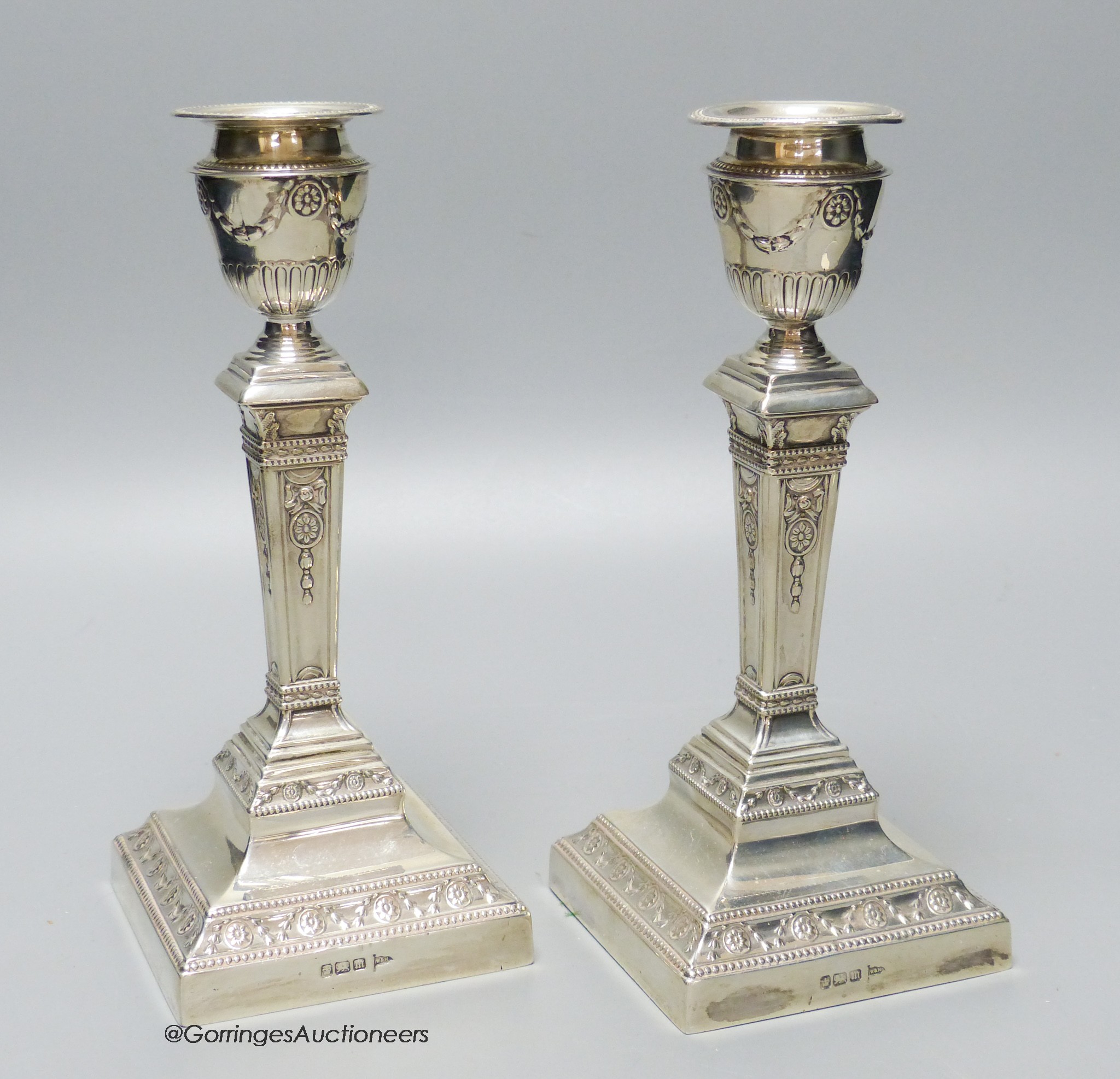 A pair of Edwardian silver pillar candlesticks, by Walker & Hall, Sheffield, 1904, 20.6cm, weighted.